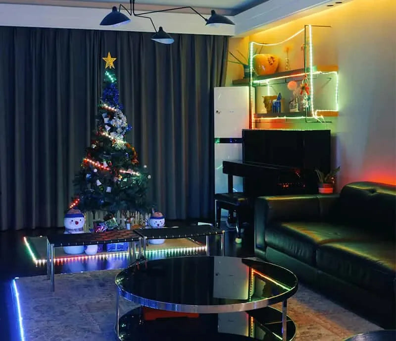The living room is decorated with color changing led light strips for the Christmas tree and display shelves and carpet.