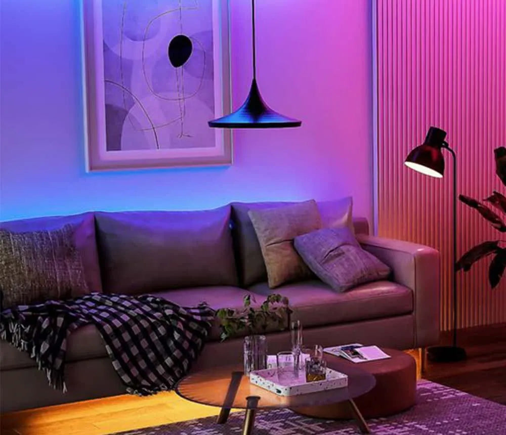 Sofa, table, and wall decorated with led strip lights.